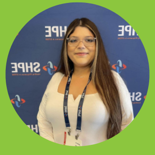 STEM Student in front of SHPE Logo wall